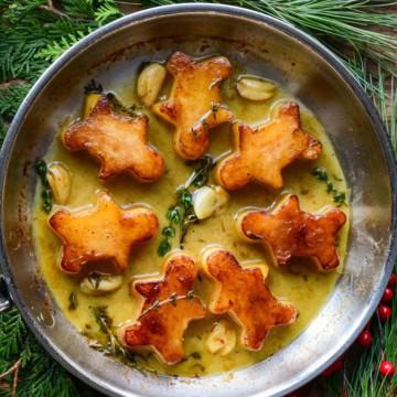 A skillet of garlic fondant potatoes in the shape of gingerbread men.