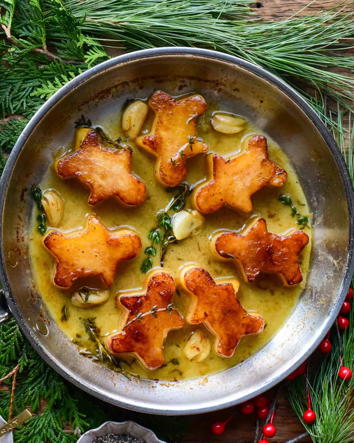 A skillet of garlic fondant potatoes in the shape of gingerbread men.