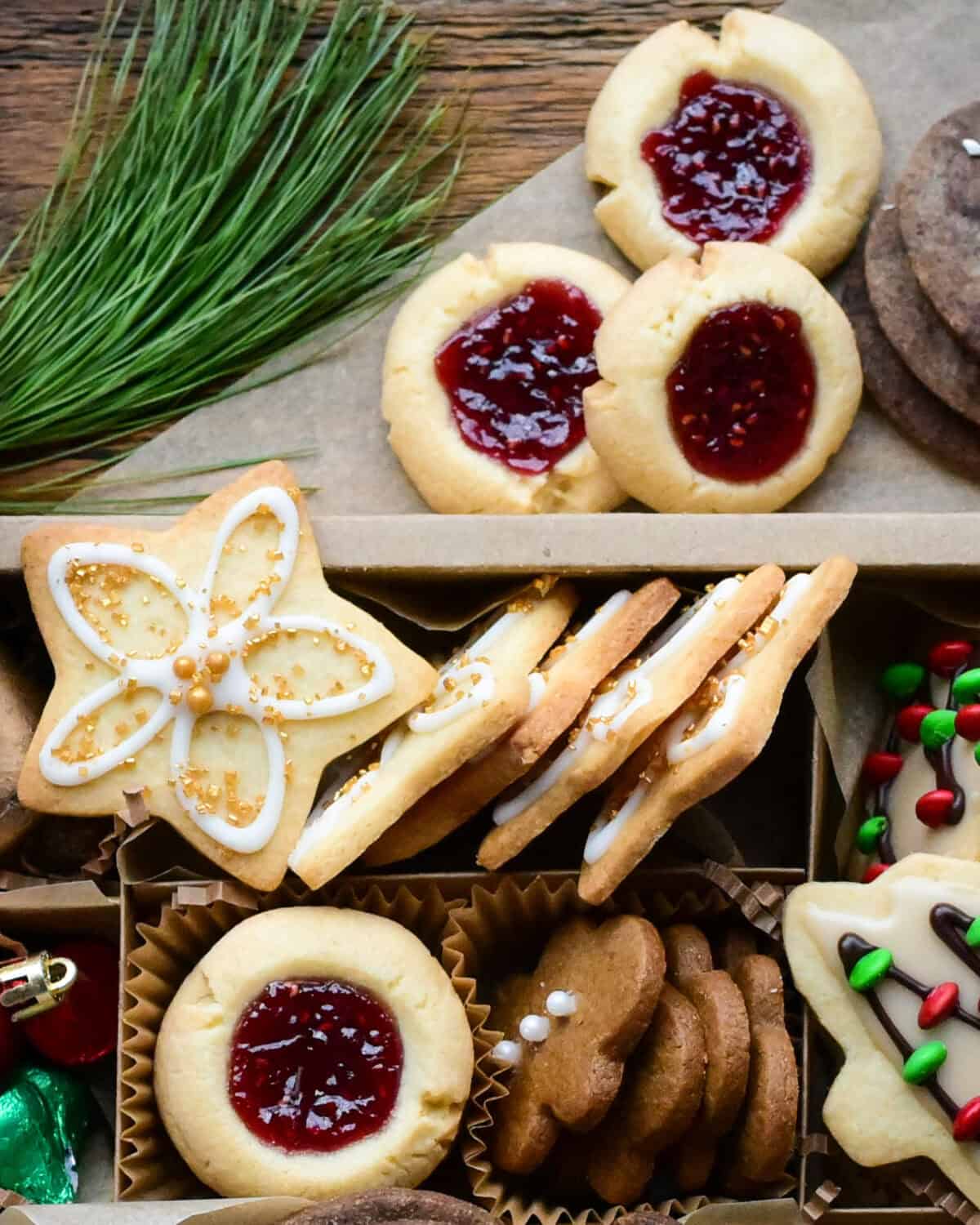 Holiday thumbprint cookies with raspberry jam in a Christmas cookie box.