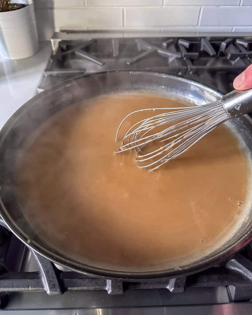 Whisk the gravy and simmer to thicken.