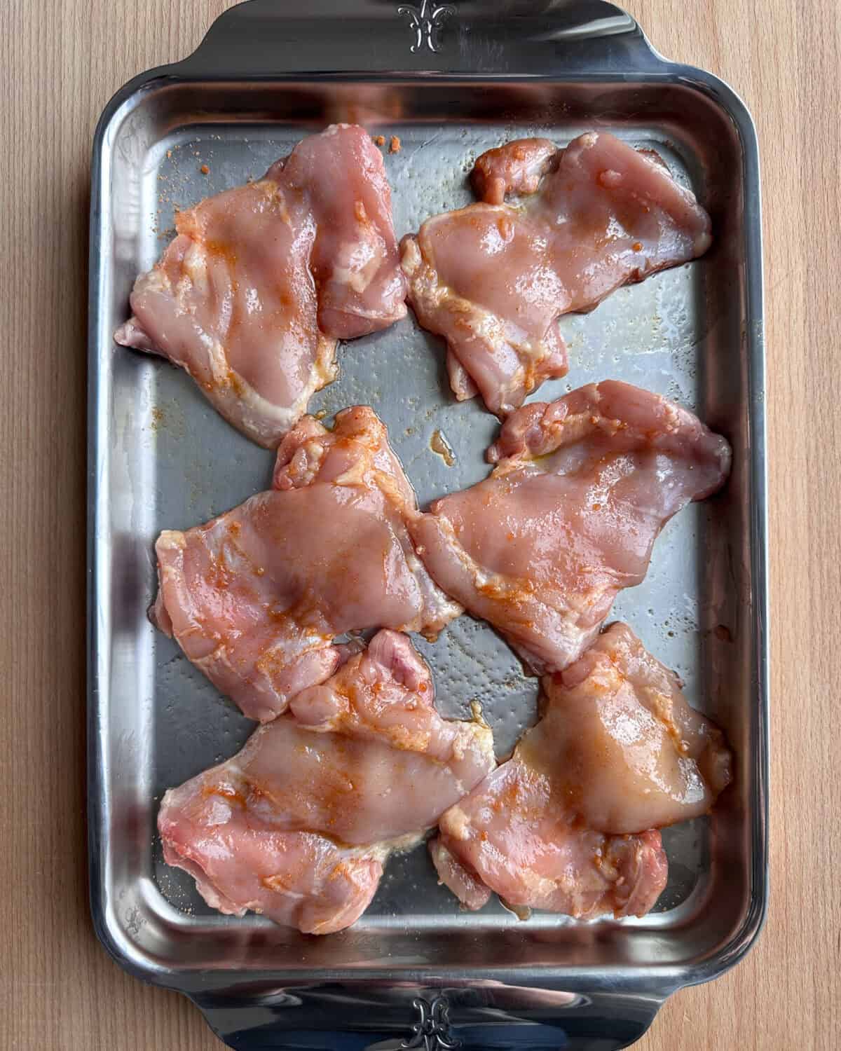 Six boneless, skinless chicken thighs seasoned and ready to get grilled.