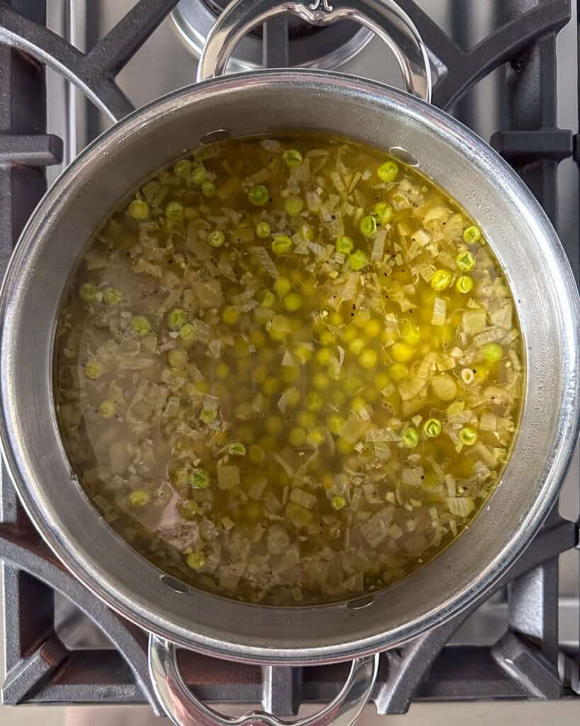 Add broth to the pot and simmer.