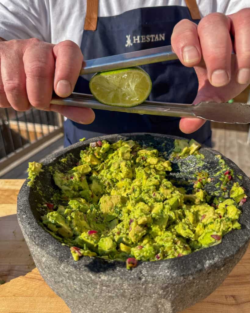 Juice the last half of the lime over the sweet corn guacamole mixture.