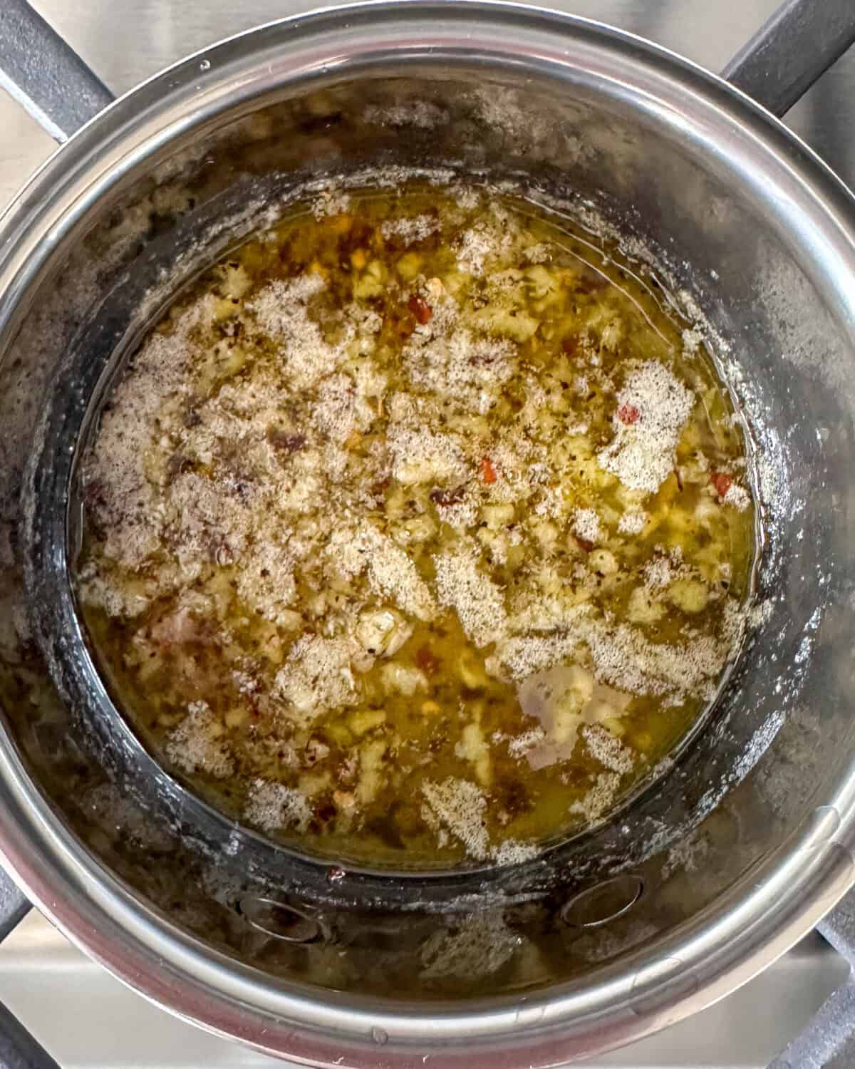 In a small pot over medium heat, add the oil, butter, garlic, salt, red-pepper flakes, and black pepper. Cook for one minute.