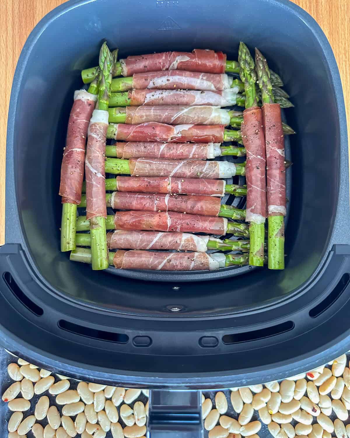Place the prosciutto-wrapped asparagus spears in the air fryer basket, we laid 12 down and placed two on each end, so that they did not overlap on the prosciutto.