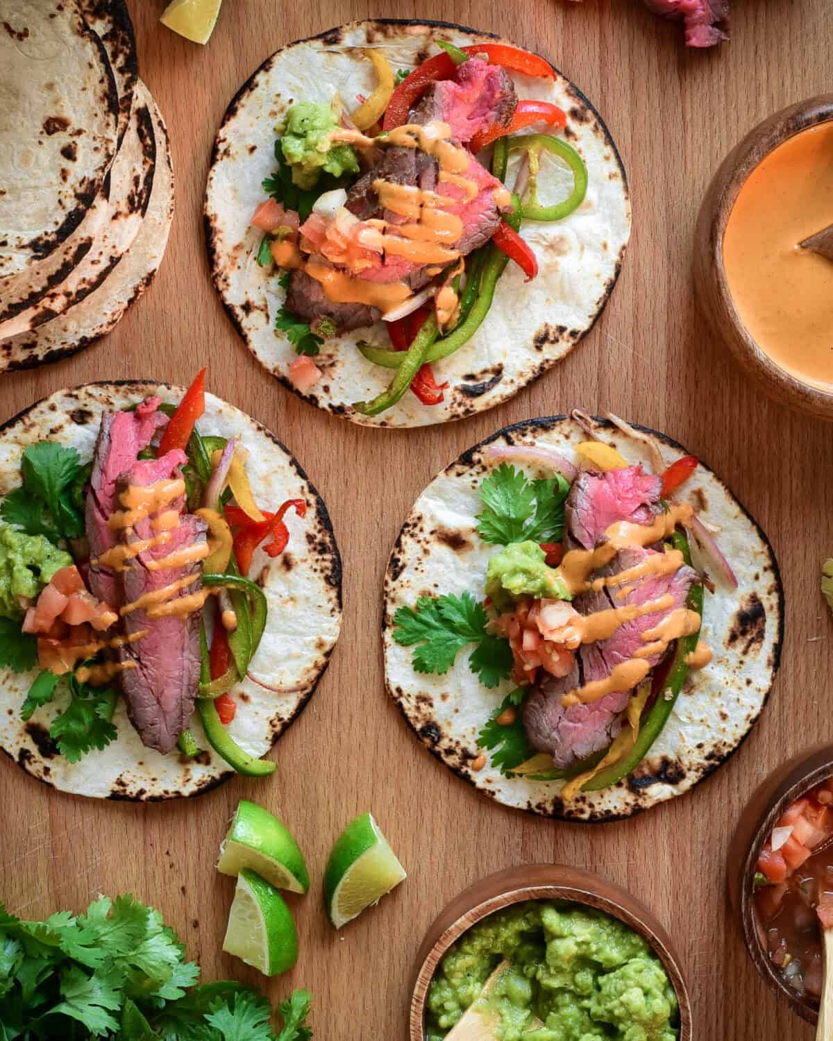 Three assembled steak fajitas.