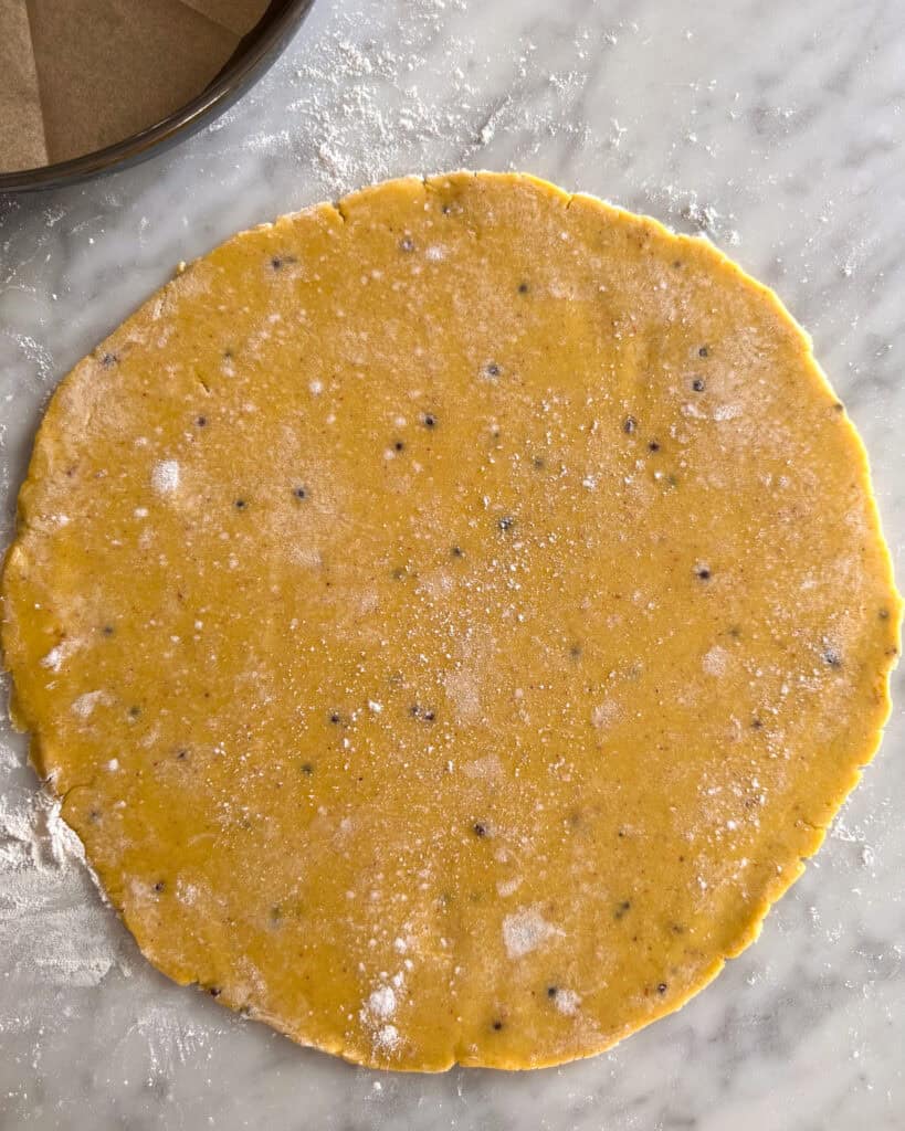 A pink peppercorn dough rolled into a circle for a galette.