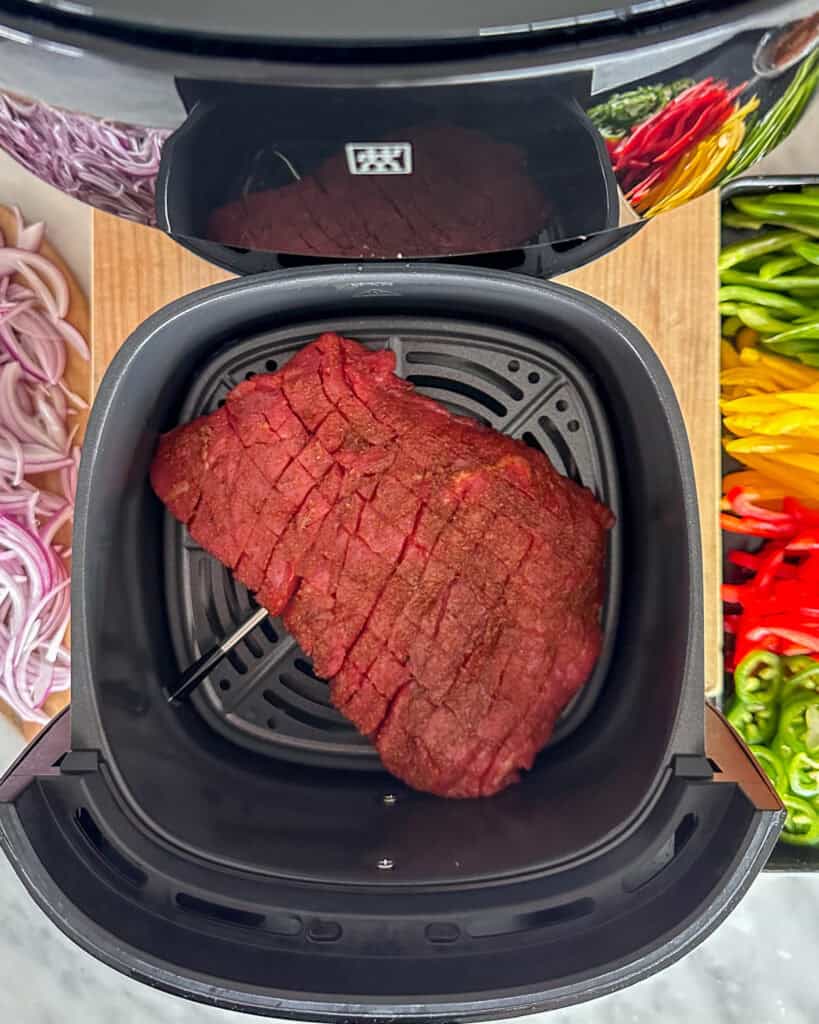 A marinated and cross hatched flank steak in the air fryer.