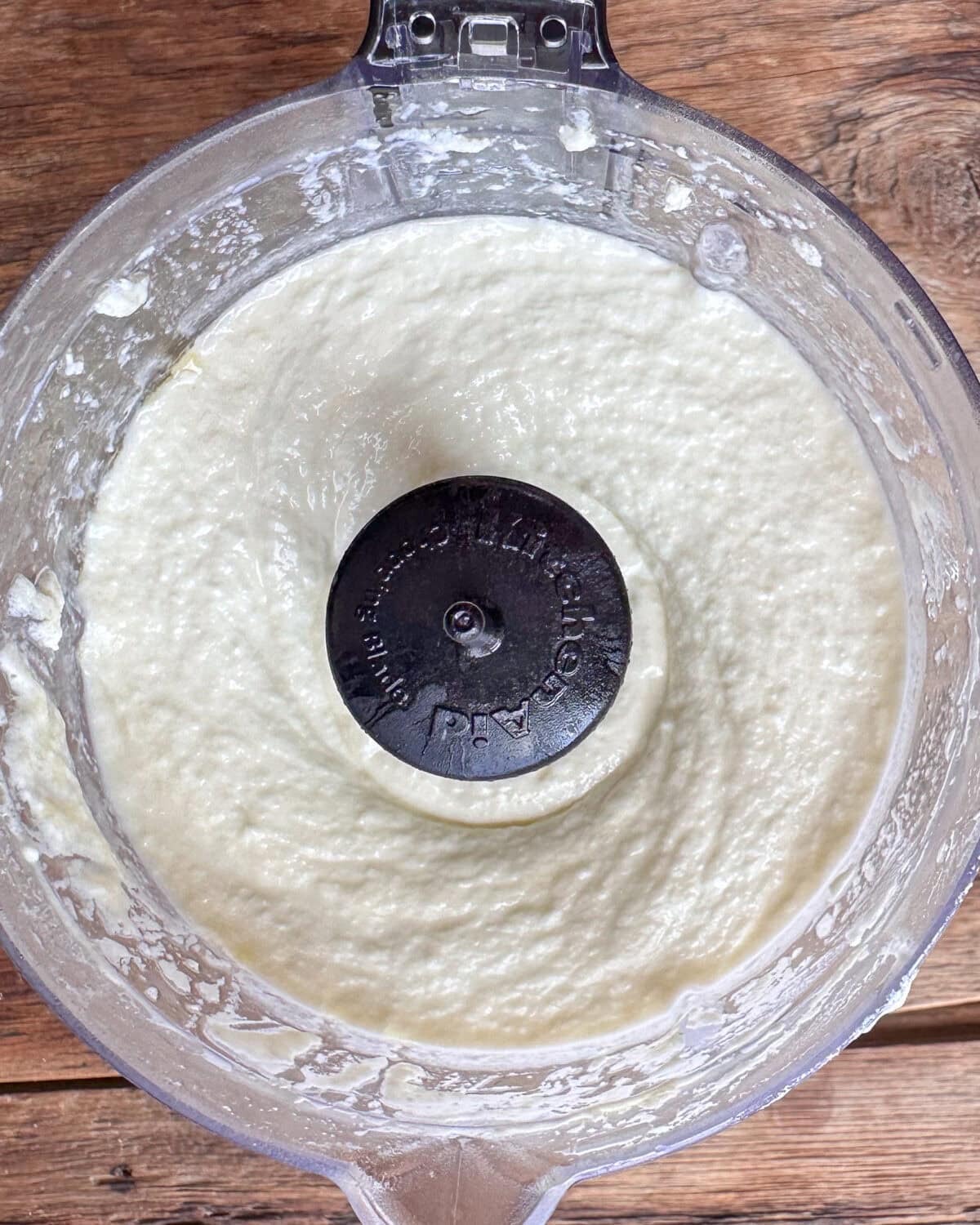 Feta in a food processor for whipped feta crostini.