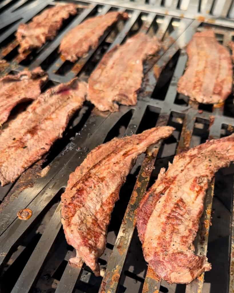 Veal leg cutlets with grill marks on the grill.