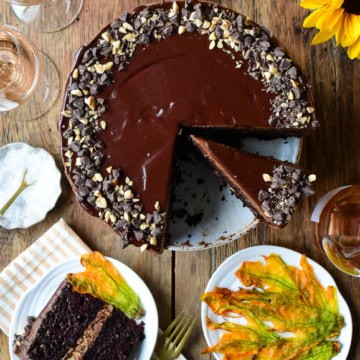 A Chocolate Hazelnut Zucchini Layer Cake with a few slices taken out. Served with Sugared Zucchini Blossoms.