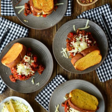 Four Weeknight Dynamite Sandwiches on plates with checkered napkins.