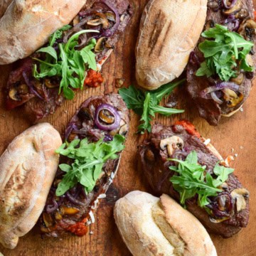Four Grilled Veal Cutlet Sandwiches with mushrooms, onions and arugula.