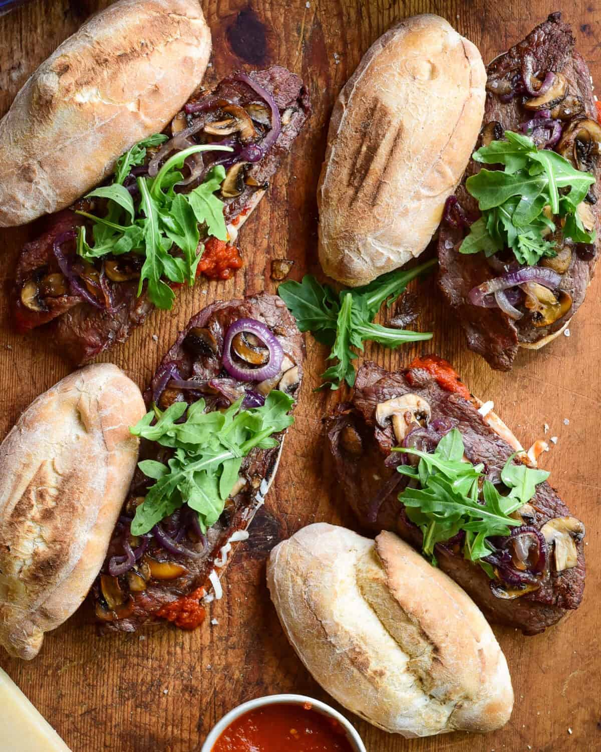 Four Grilled Veal Cutlet Sandwiches with mushrooms, onions and arugula.