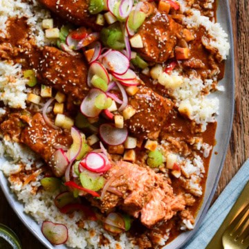 A plater with Baked Curry Salmon with Coconut Rice and and apple salsa.