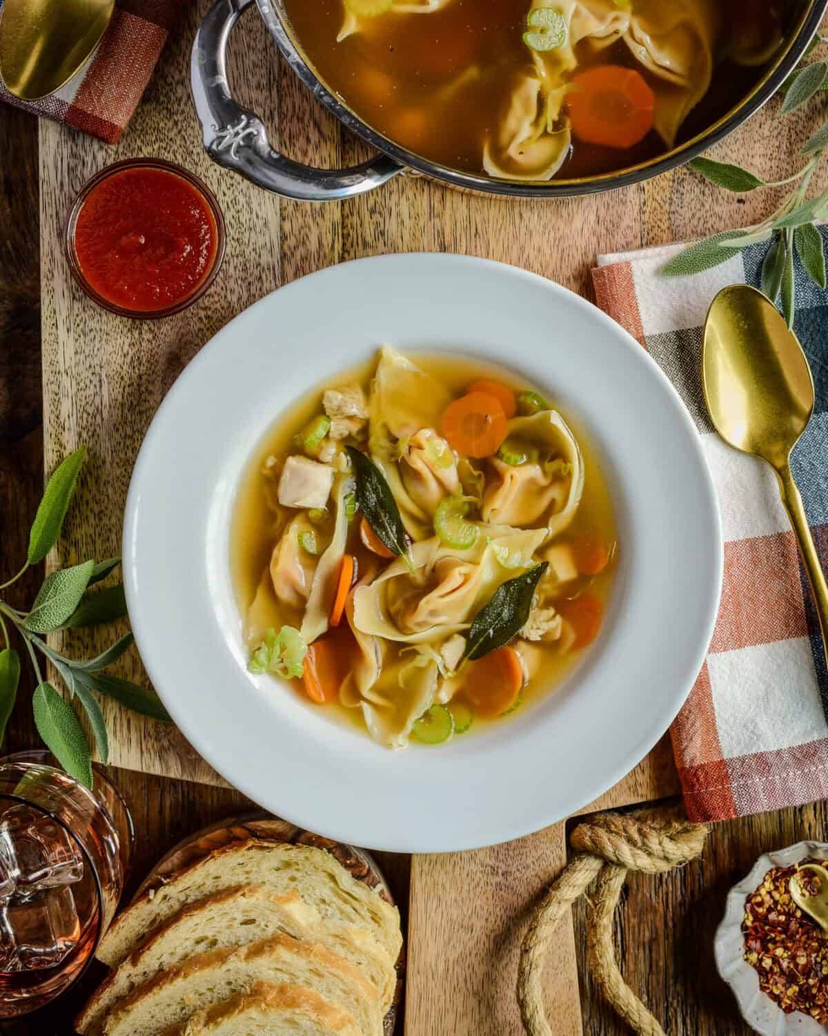 A bowl and pot of turkey soup with squash wontons.