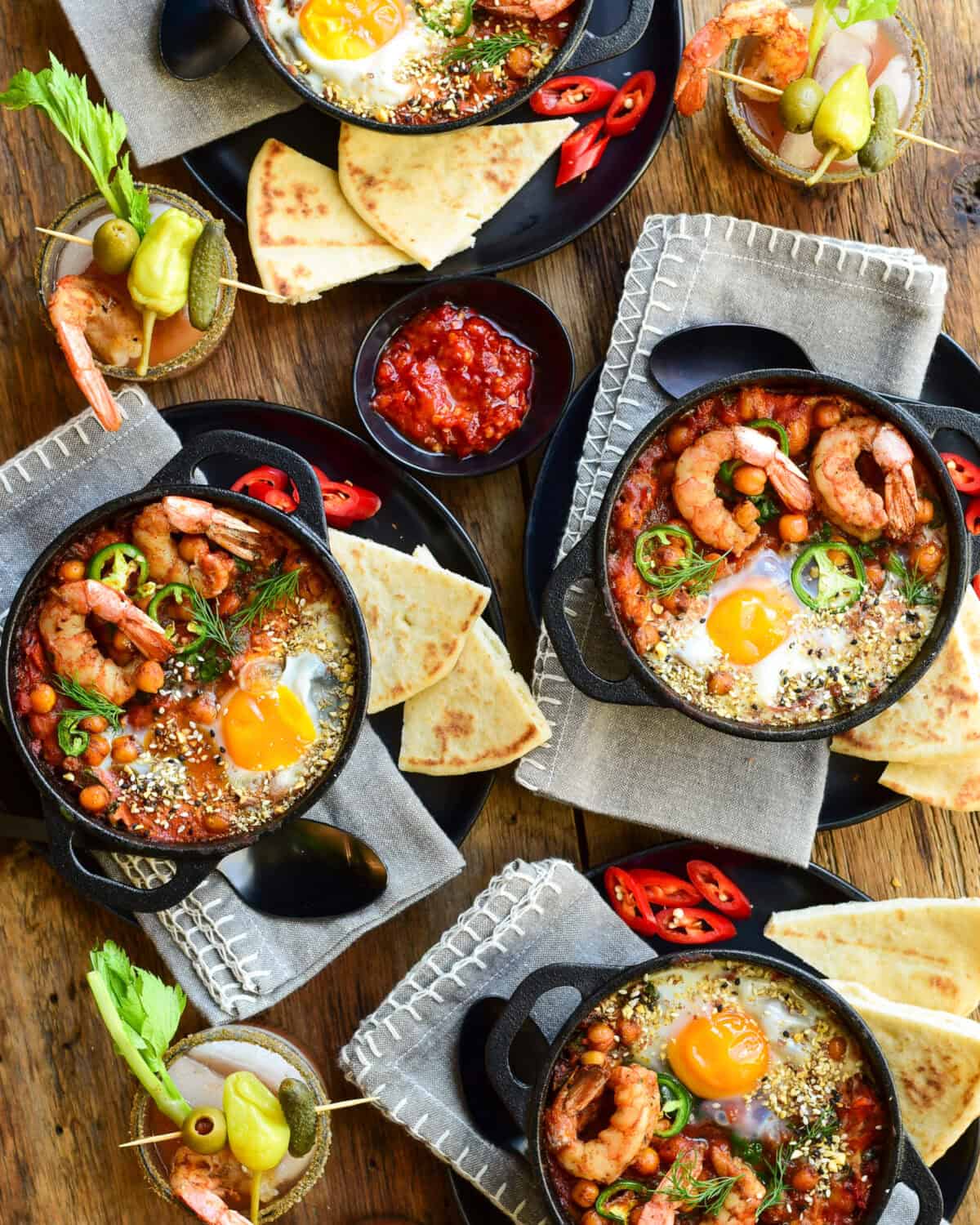 Shrimp shakshukas served in small cast iron skillets, served with naan and mini bloody Mary's . 