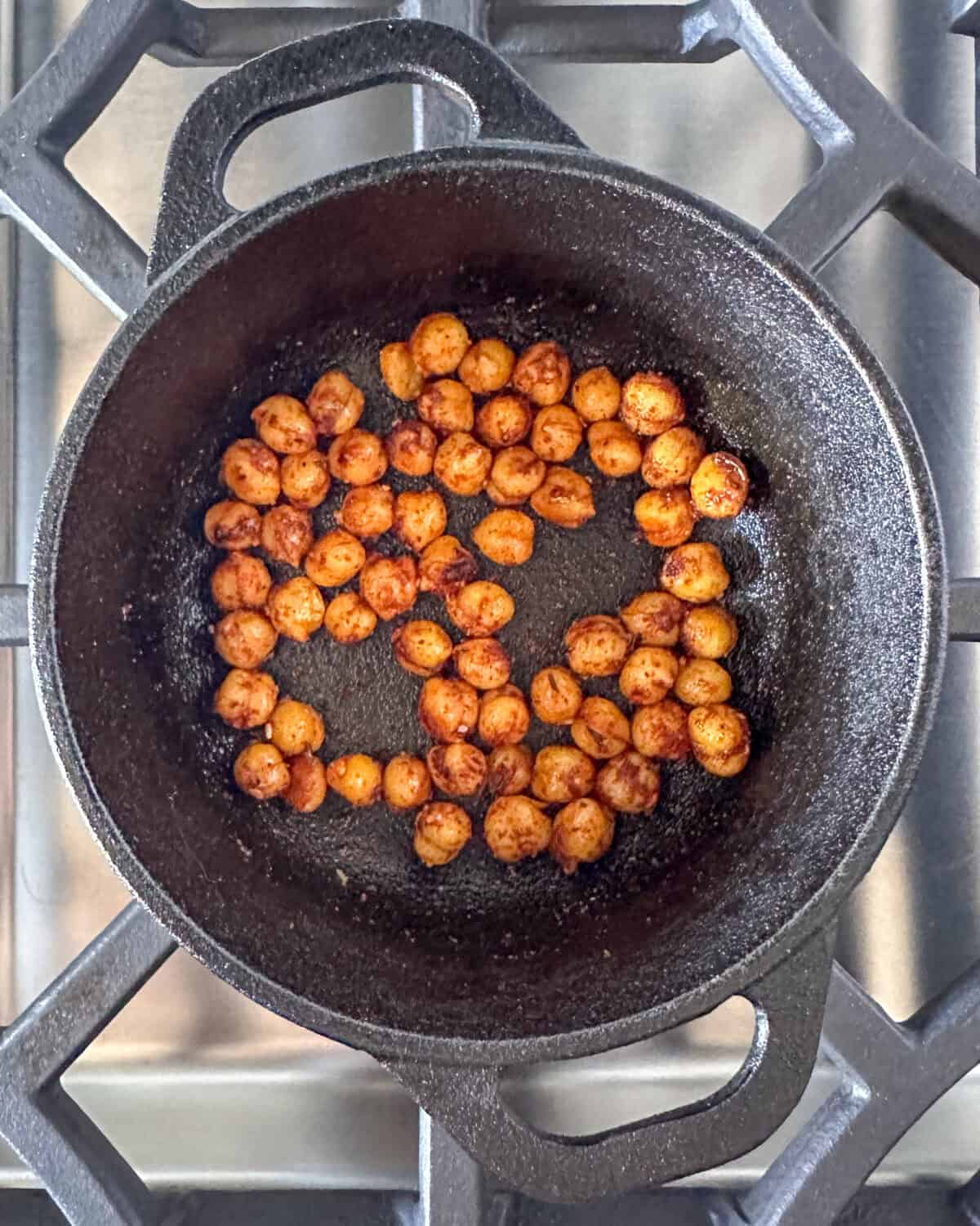 Season chickpeas in a skillet.