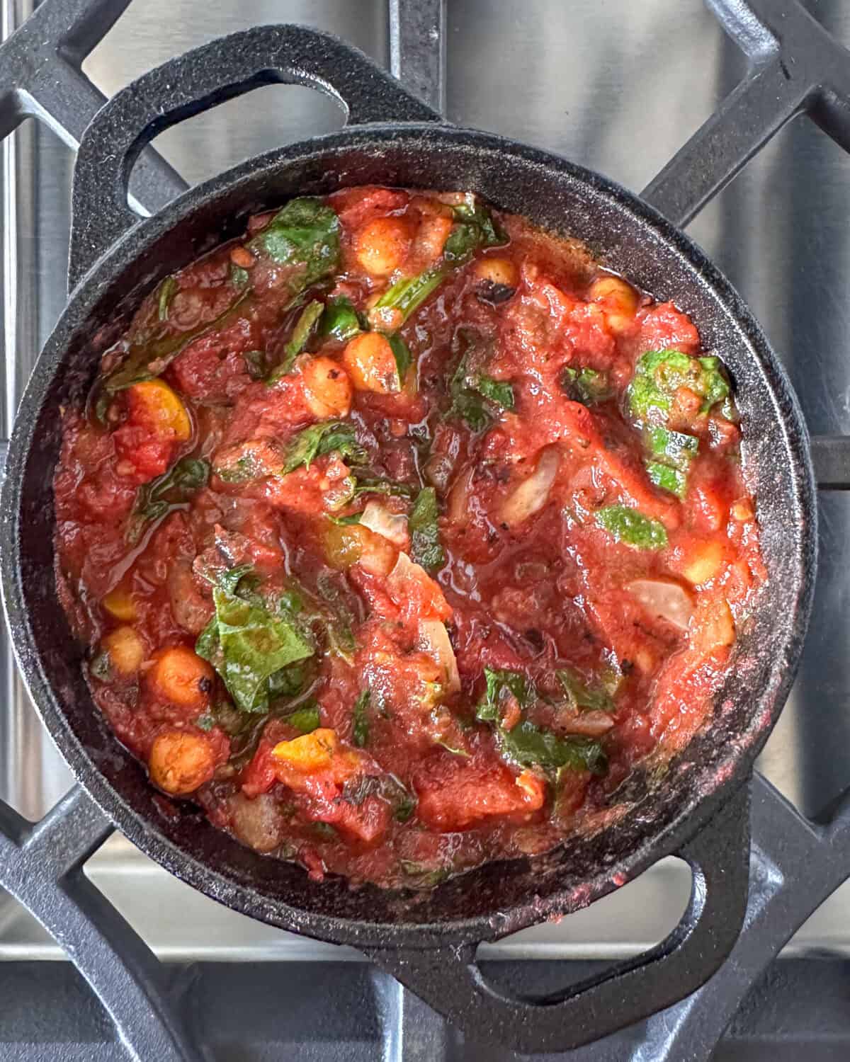 A cast iron skillet of shakshuka sauce simmering.
