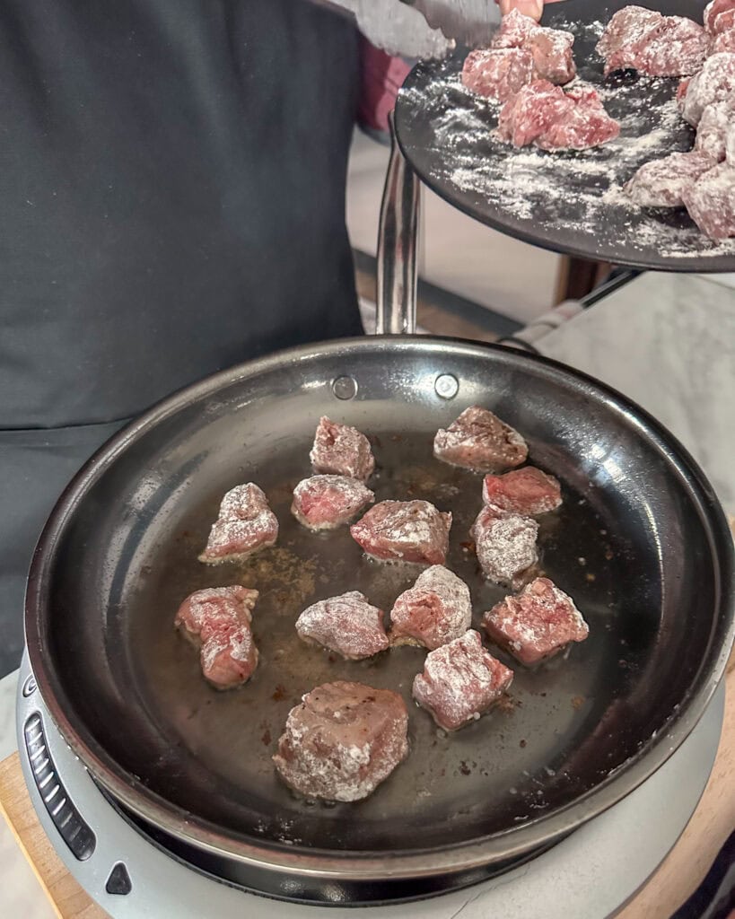 Sear the flour coated beef cubes in beef tallow.