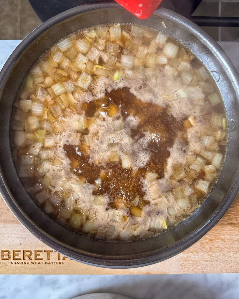 Pour in the beef stock and scrape up the browned bits from the skillet.