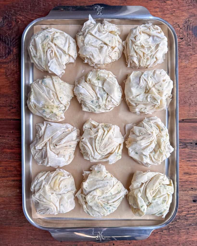 Twelve surf and turf phyllo appetizers on a tray.