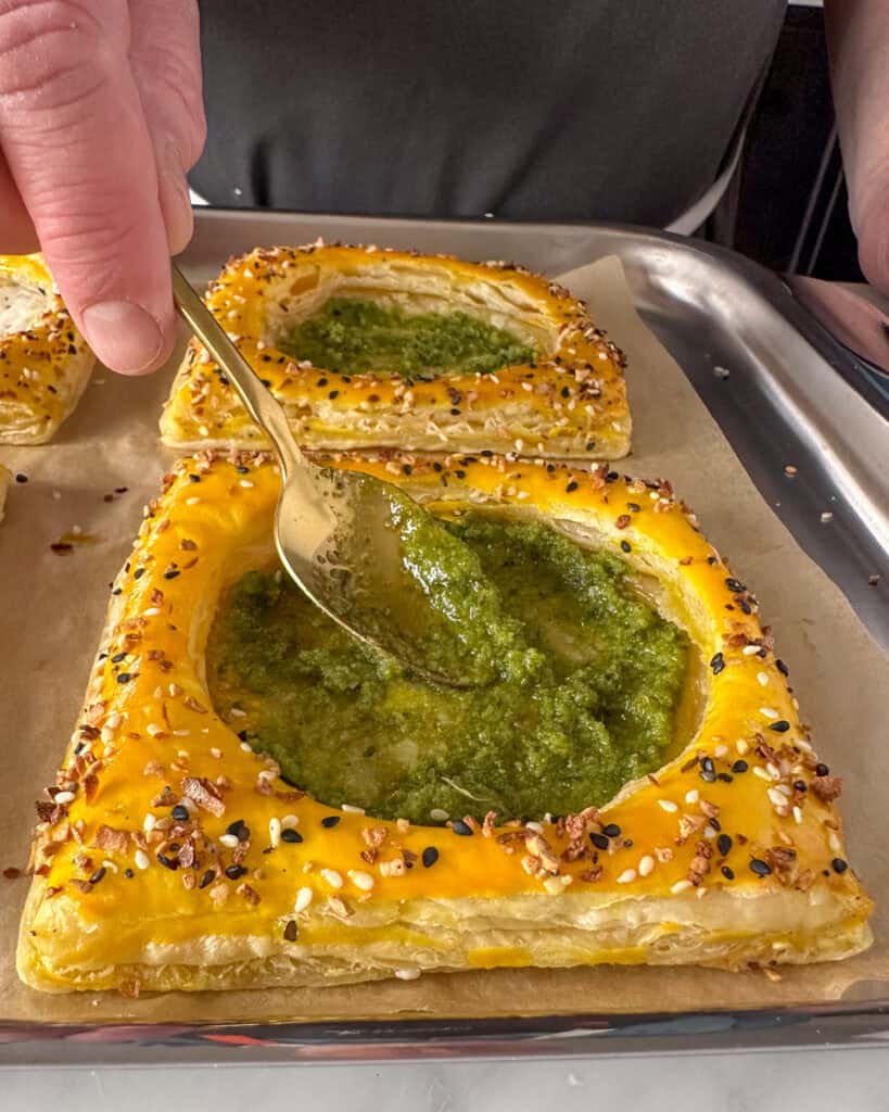 Add pesto into each puff pastry breakfast tart.