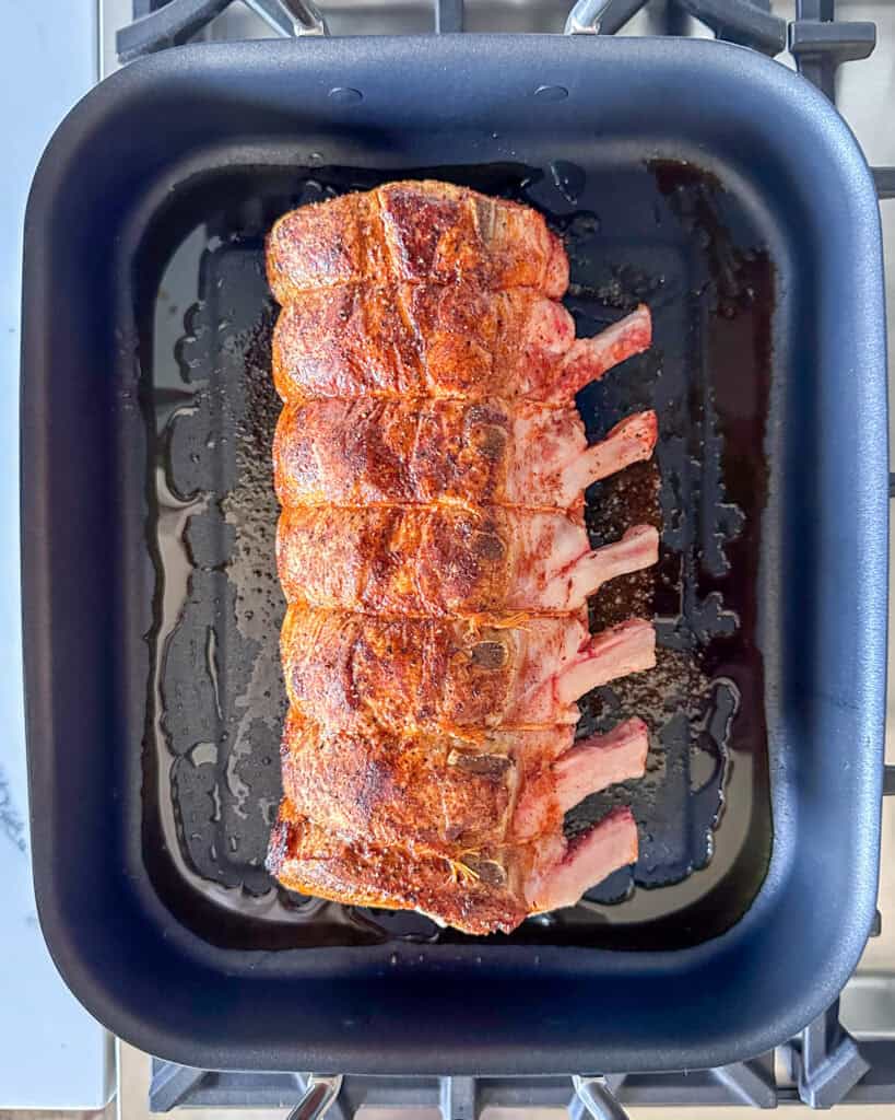 Sear the frenched pork roast.