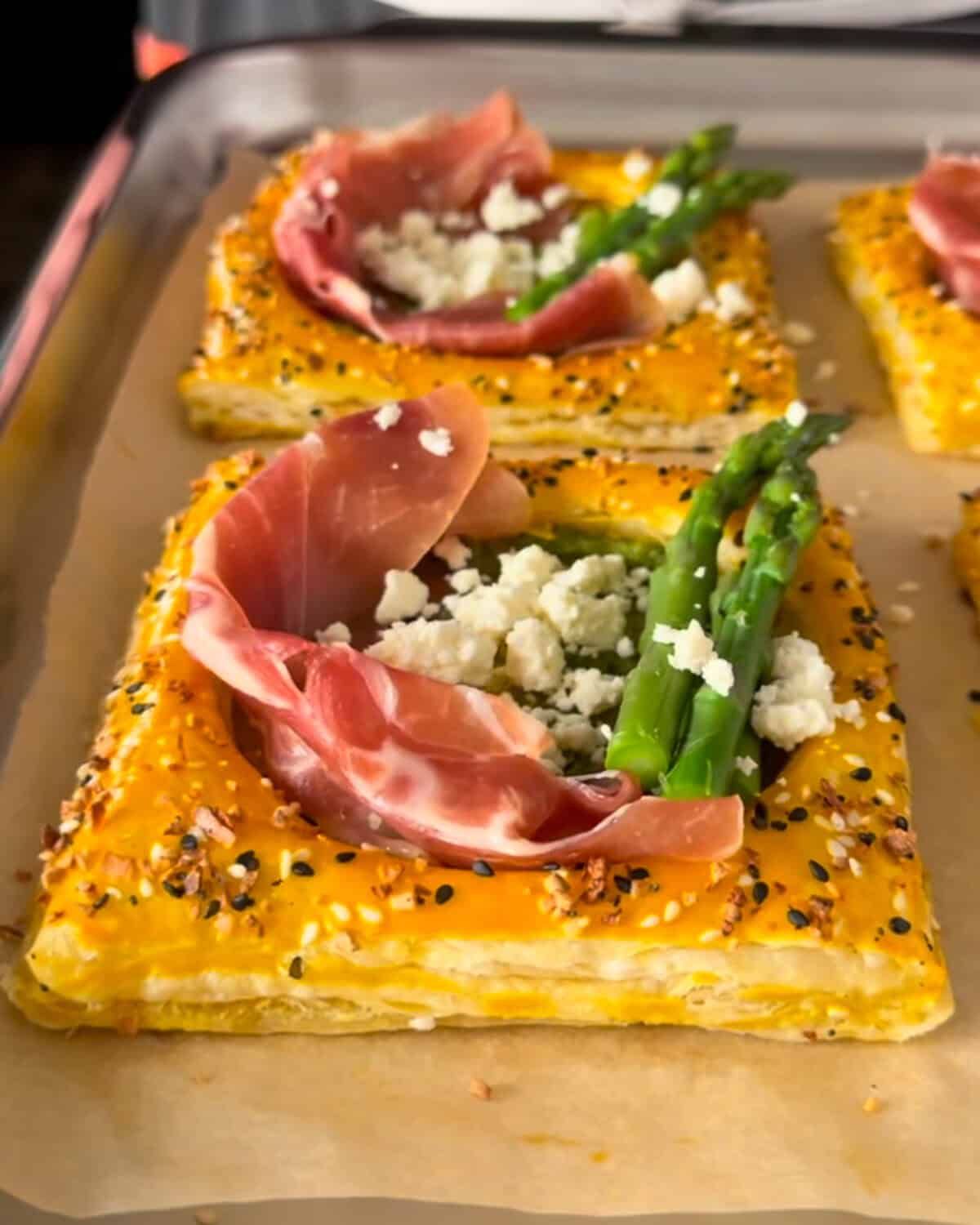 Add the prosciutto, asparagus and crumbled feta to the center of the puff pastries.