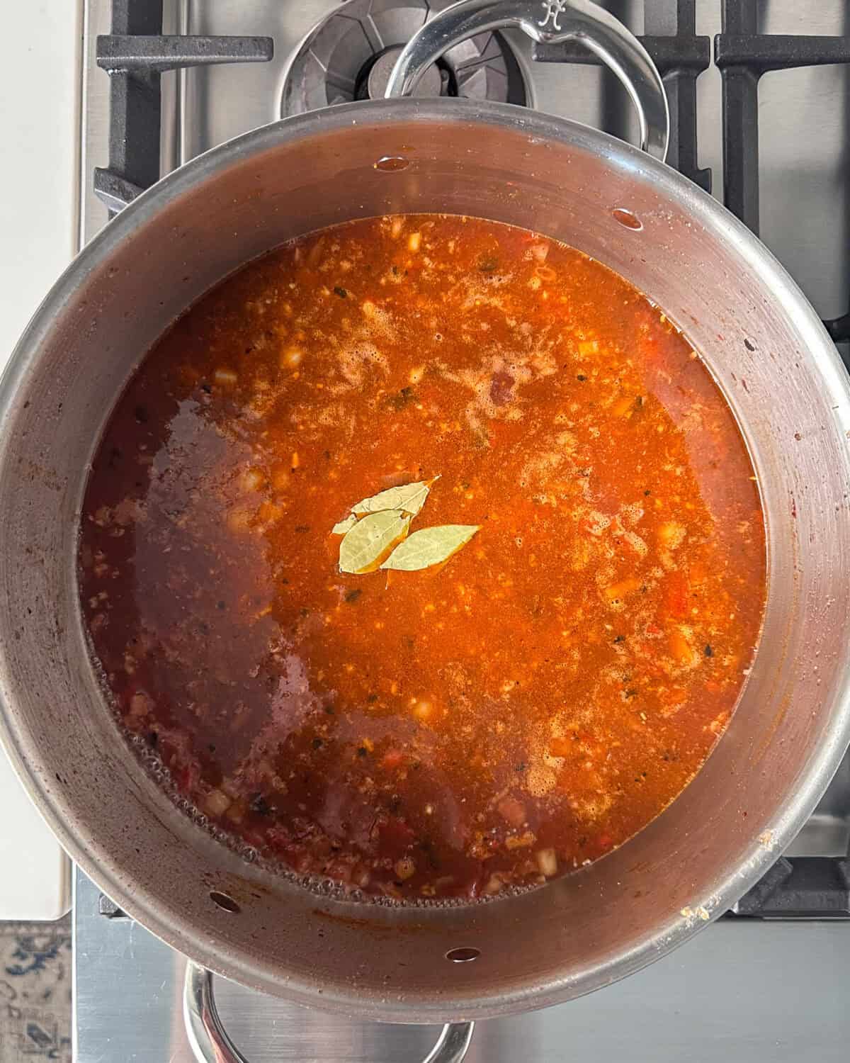 Add the vinegar, stock and bay leaves to the stew.