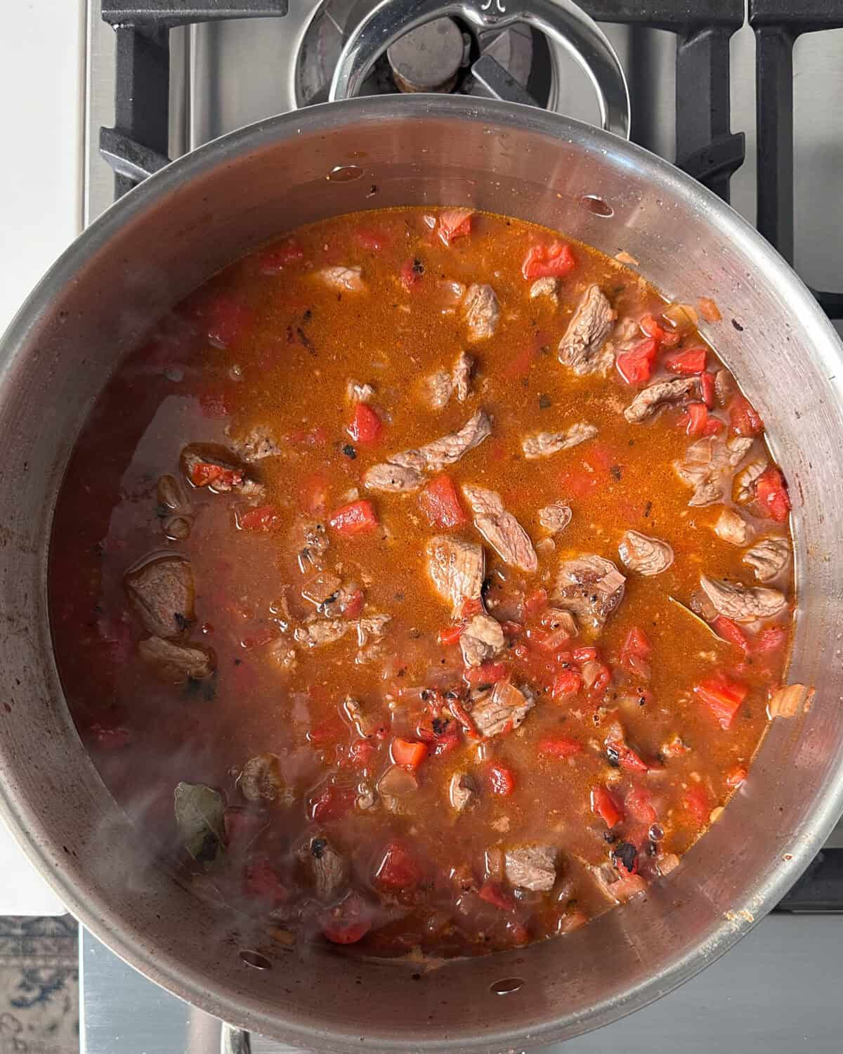 Return the lamb to the pot, adding rosemary and thyme sprigs.
