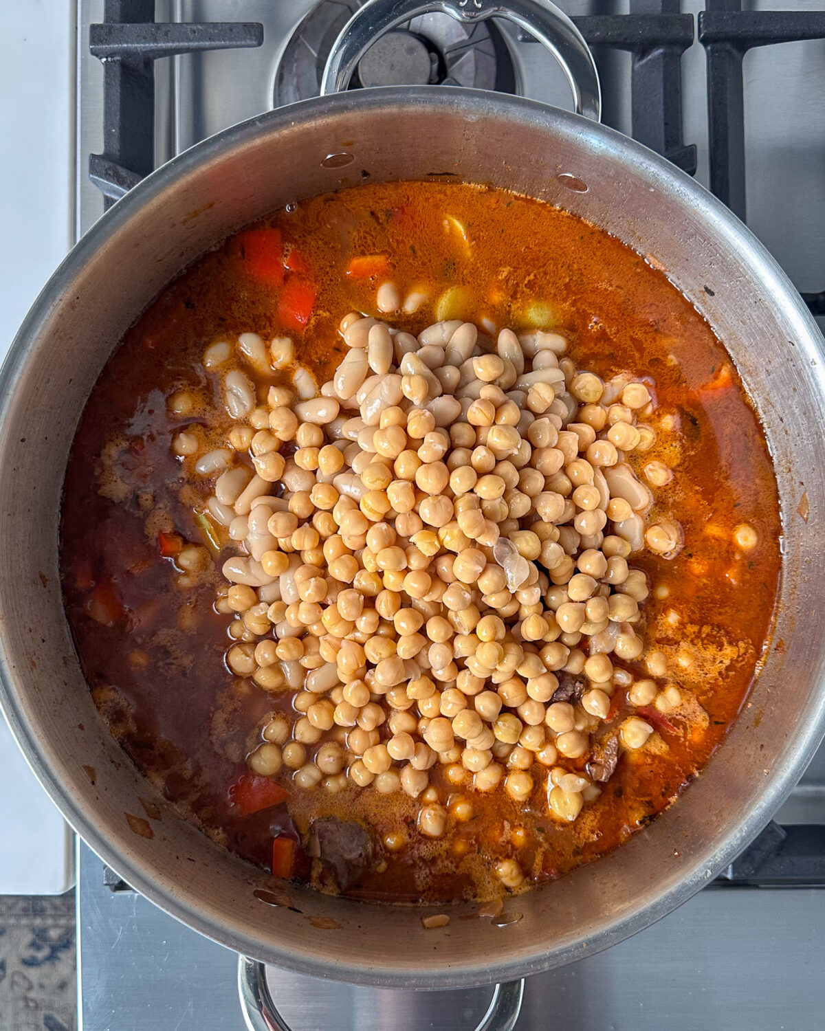 Add white beans, chickpeas and cherry tomatoes to the boneless leg of lamb stew.