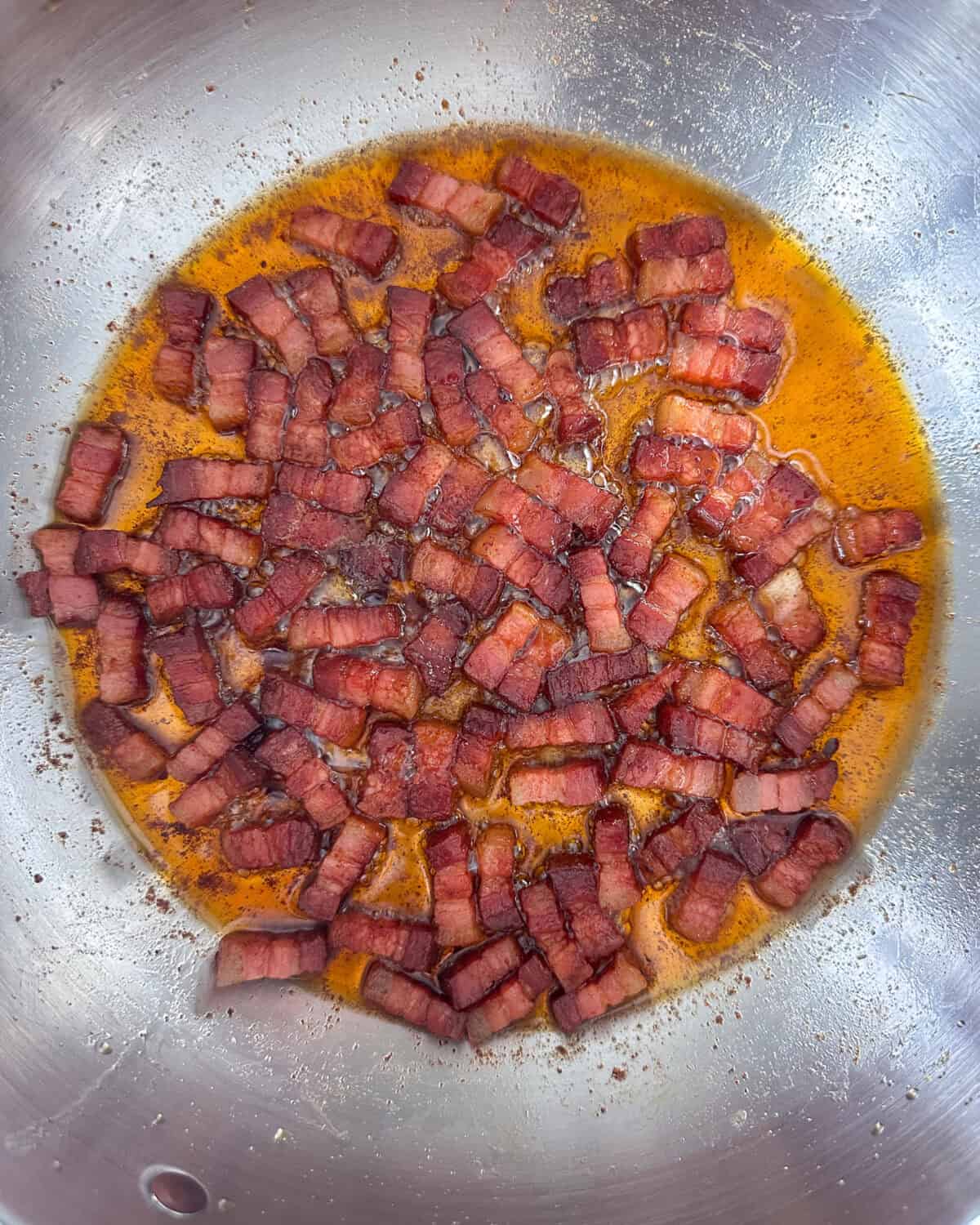 Rendered pancetta in a pot for a beef stew.