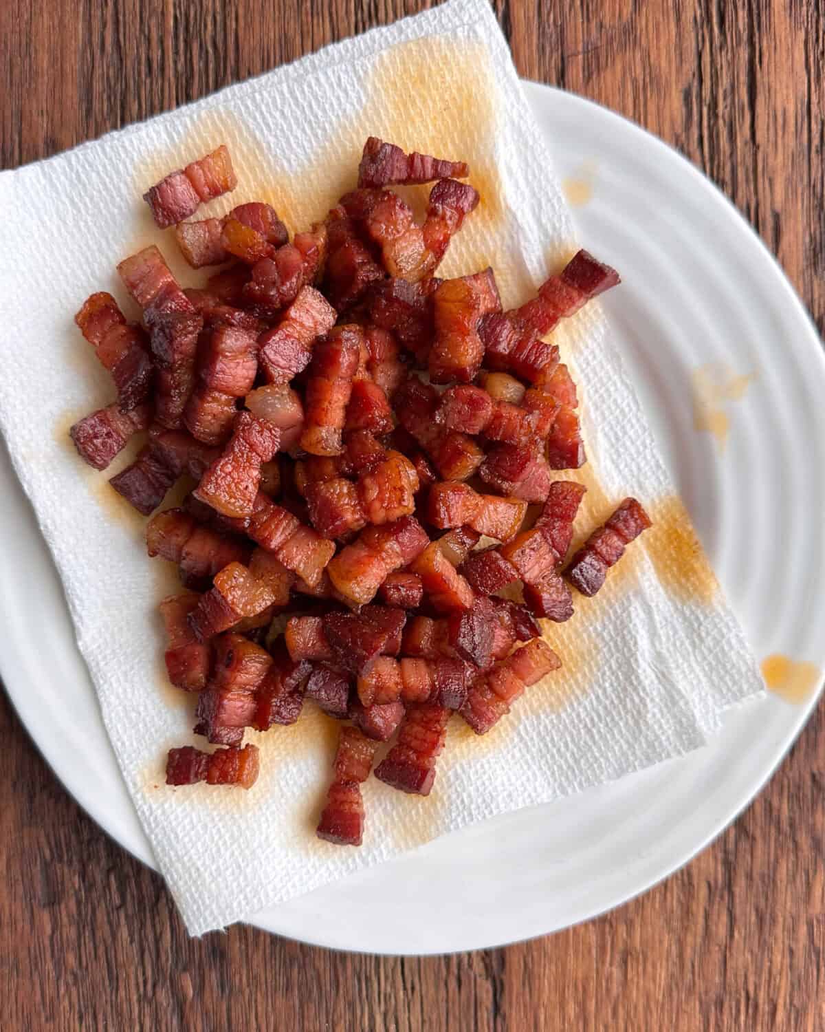 Rendered pancetta on a paper towel-lined plate.