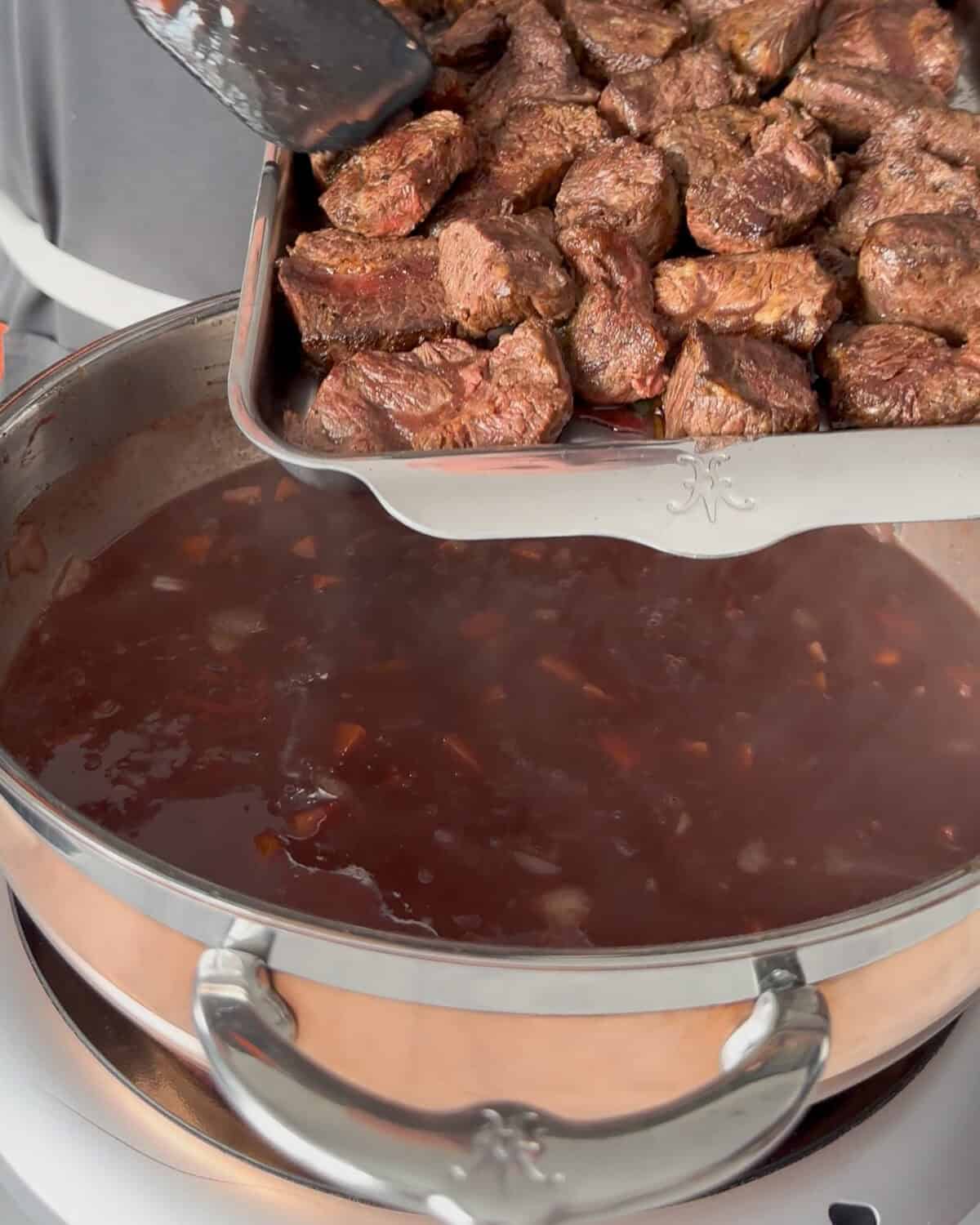 Return the beef, along with any juices, to Dutch oven.