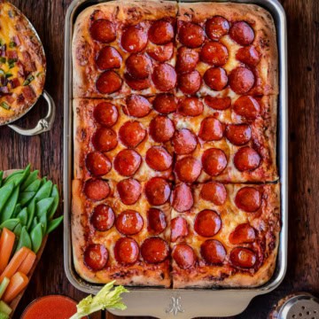A golden, crispy pepperoni sheet pan pizza with cup and char pepperonis.