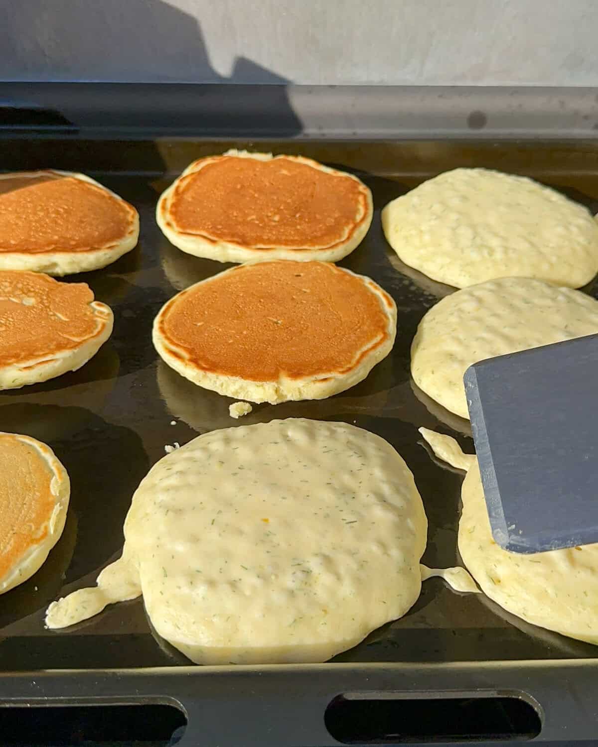 Flip the pancakes on the griddle when bubbles form.
