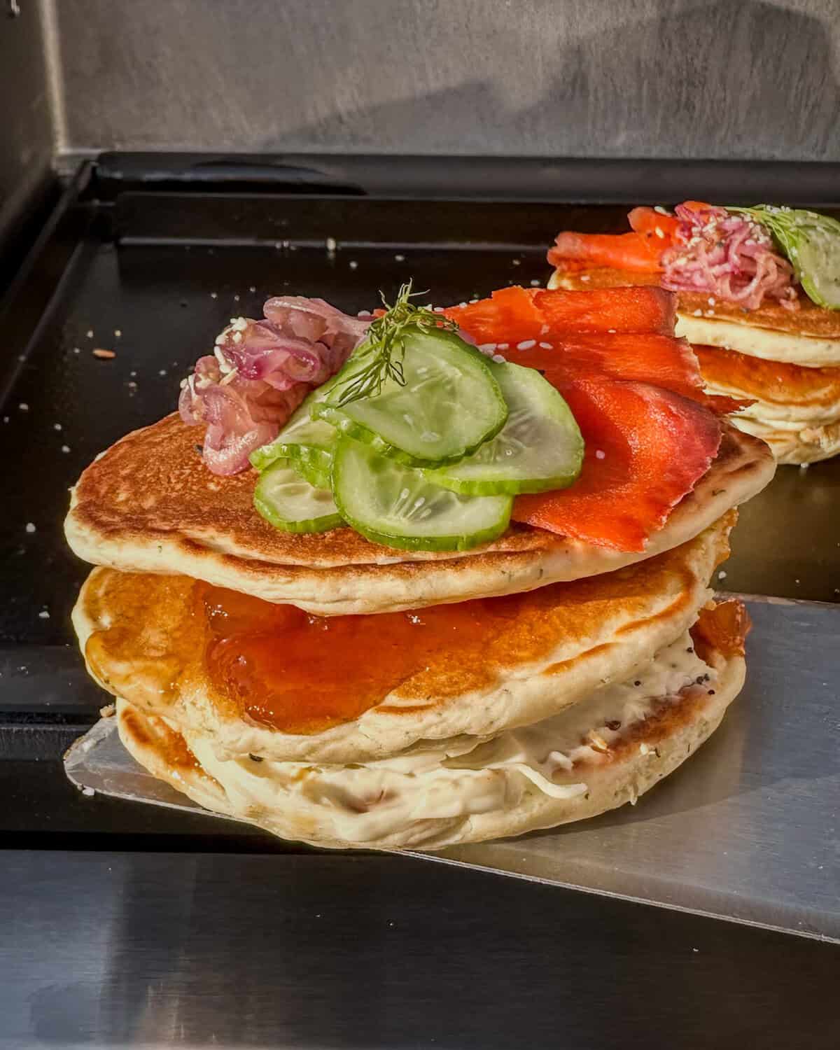 Two pancakes with smoked salmon and other toppings.