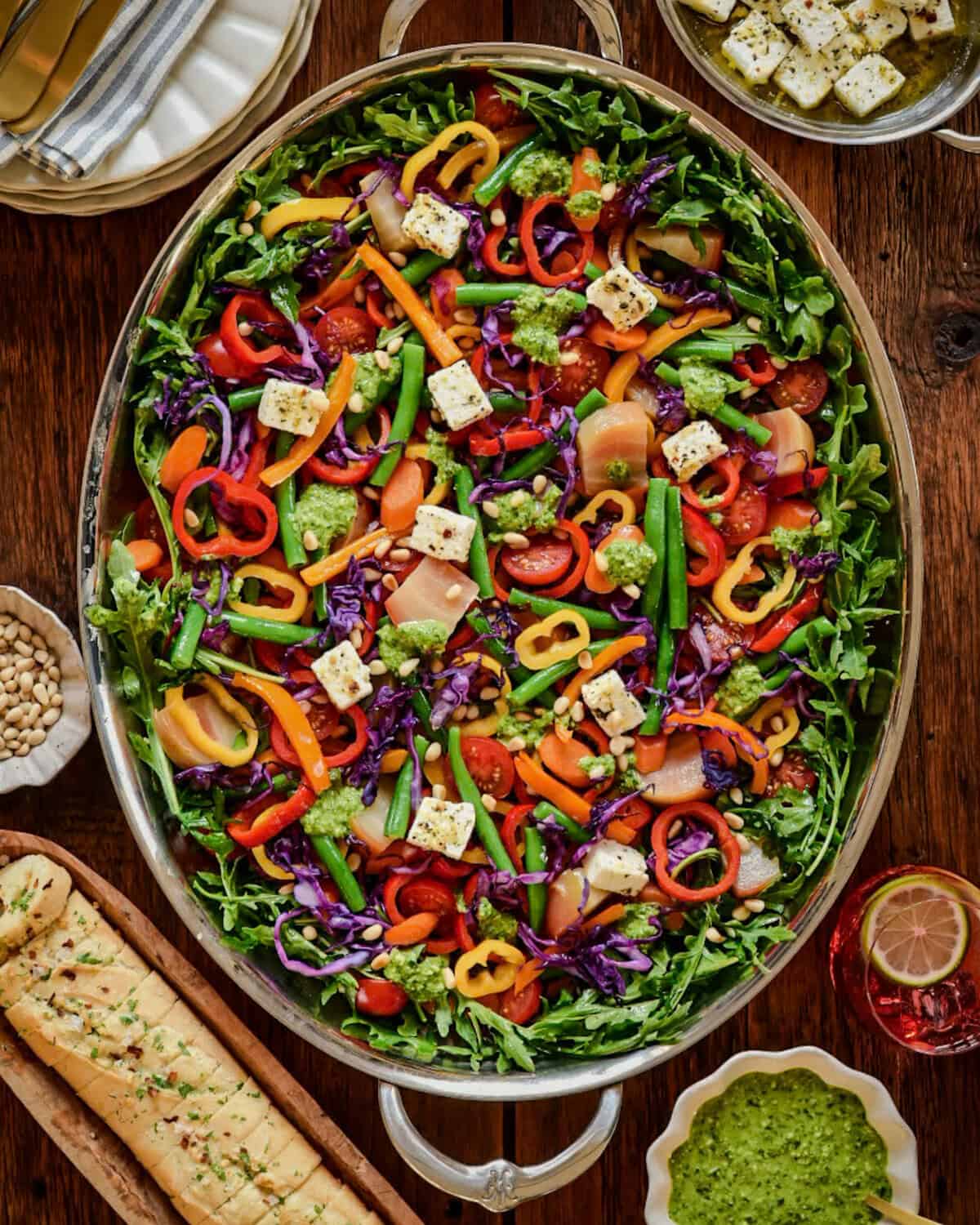 A rainbow salad served with pesto, marinated feta and bread.