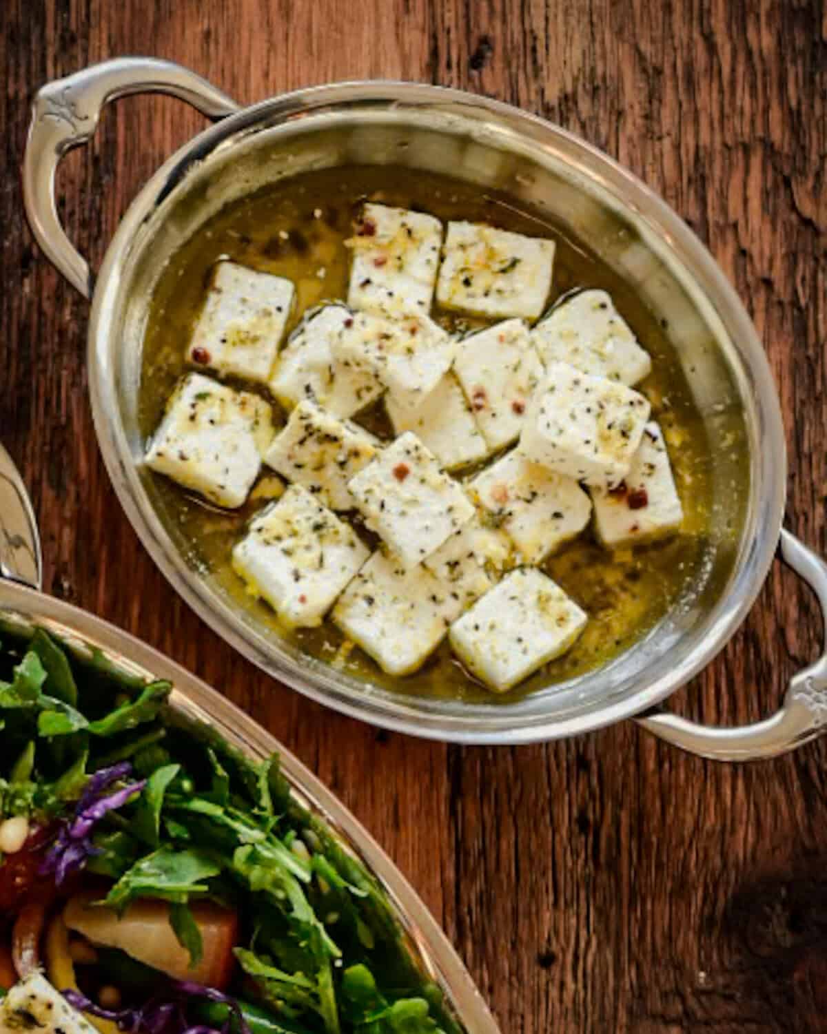 Marinated cubes of feta in an oval dish.