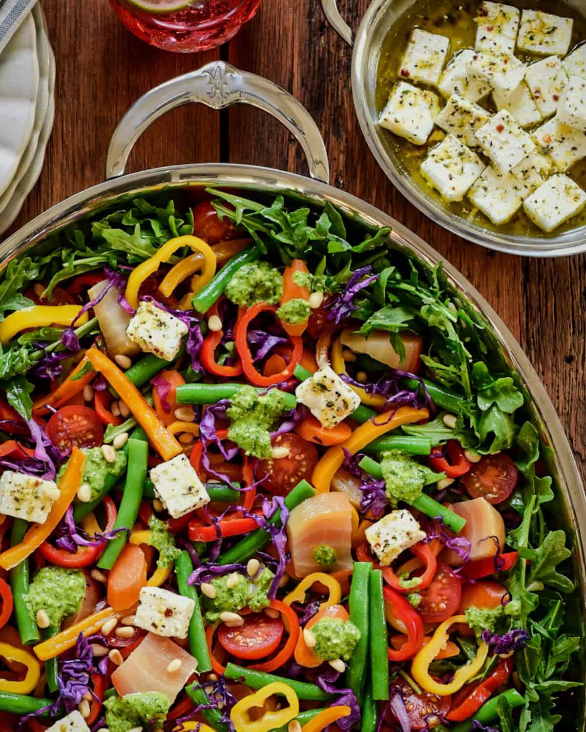 A Warm Rainbow Veggie Salad served with Fresh Summer Pesto and marinated feta cheese.