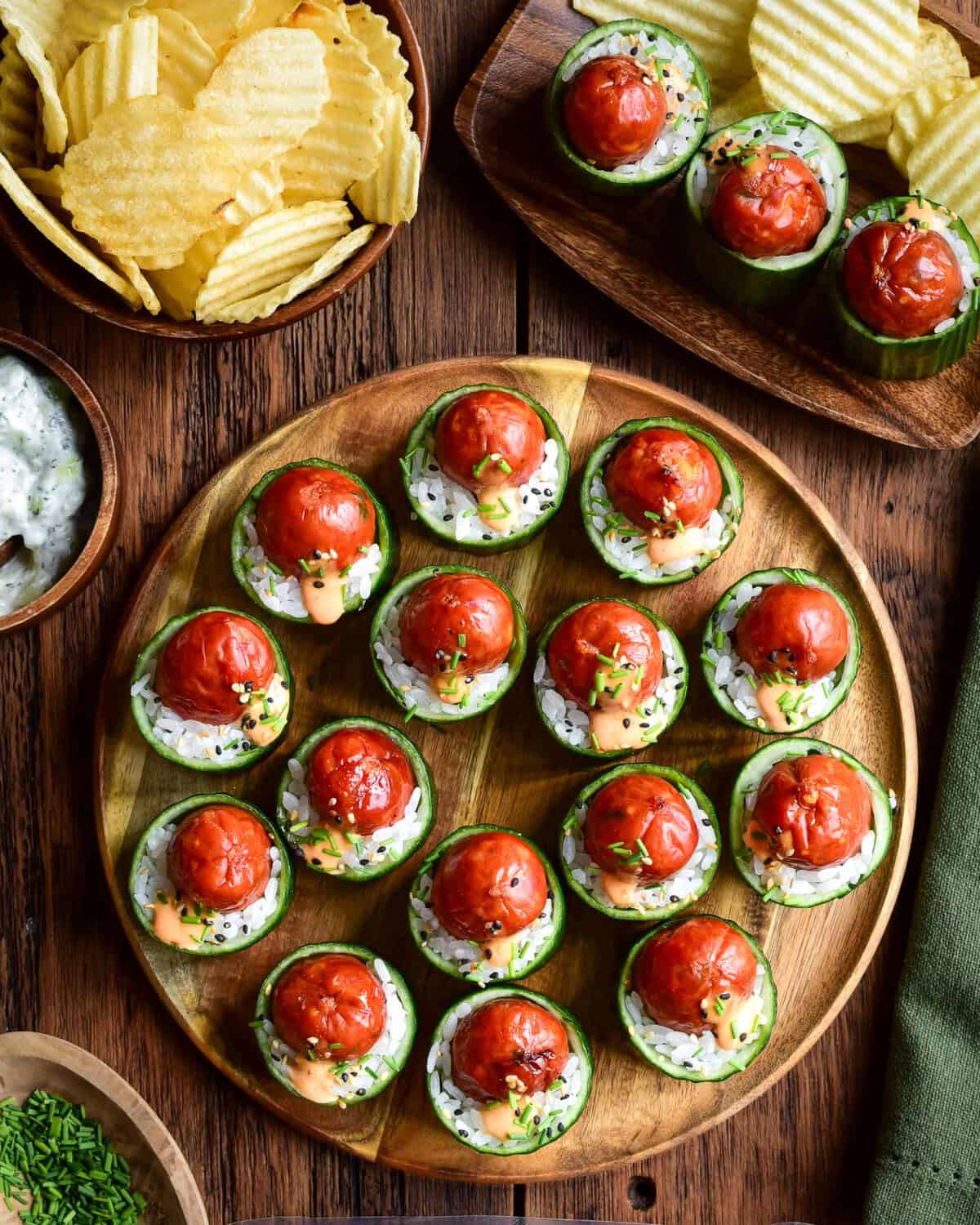 A platter of Warm Smokie Popper Sushi Bites in Cucumber Cups. Served with chips and a cucumber dip.