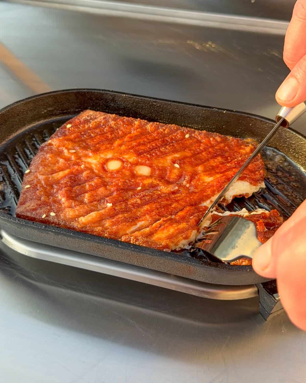 Cutting into a slab of Greek Kefalortyri cheese.