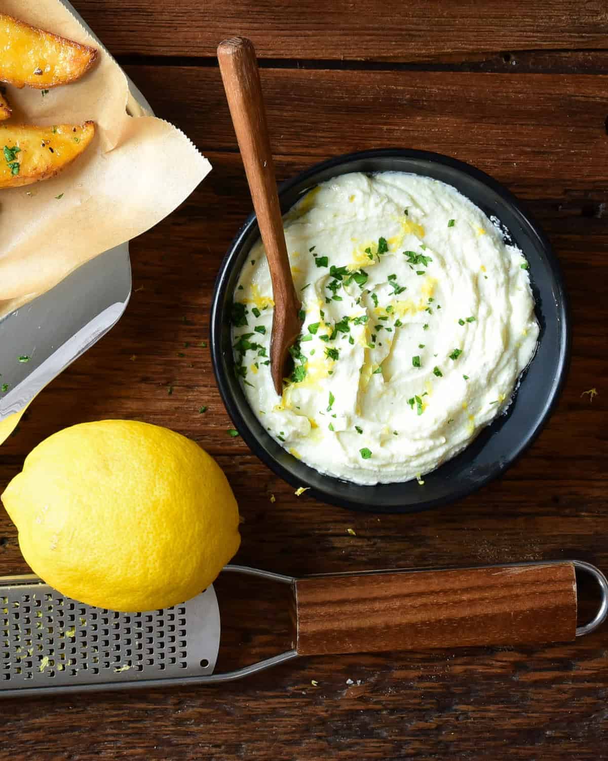 A bowl of whipped feta sprinkled with lemon zest and parsley.