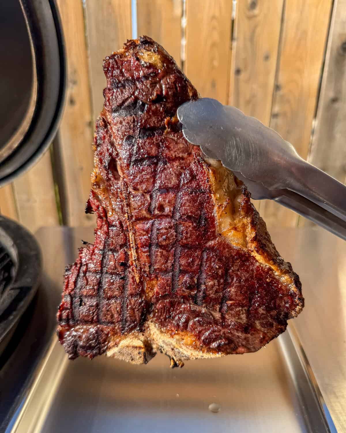 A grilled porterhouse steak with beautiful grill marks for a surf and turf with shrimp dinner.