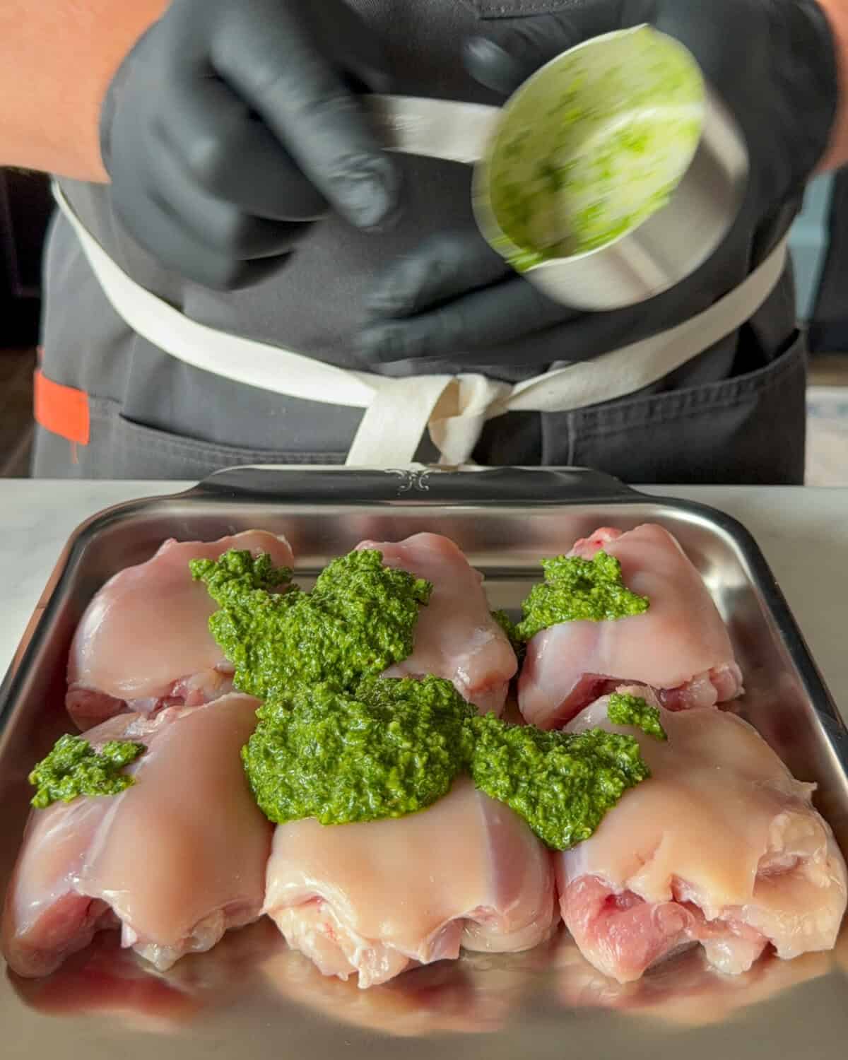 Place the zhoug paste on the chicken thighs.