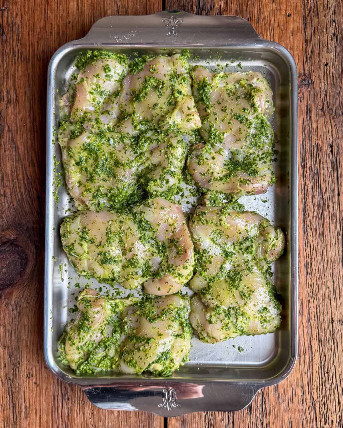 Six skinless, boneless chicken thighs marinating in a zhoug paste for a pasta salad with roasted vegetables.