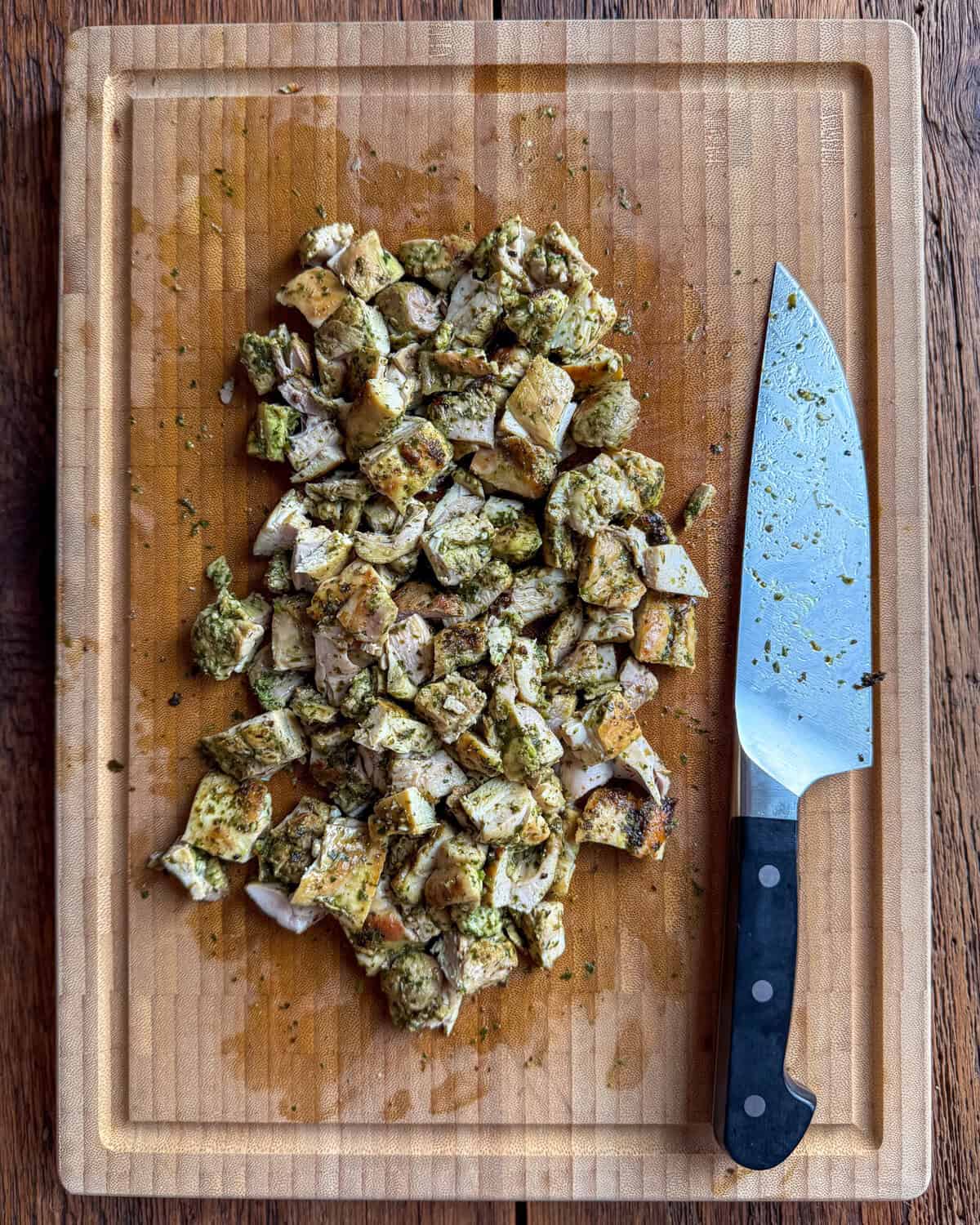 Cut pieces of chicken to be added to a pasta salad with roasted vegetables.
