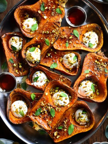 A platter of roasted Honeynut squash brulee topped with labneh, maple drizzle, mint and crushed pistachios.