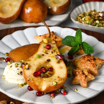 Honey roasted pear halves served with marscarpone, pistachios, puff pastry stars, mint and pomegranate arils.